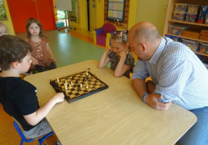 Chłopiec z dziewczynką grają w szachy.